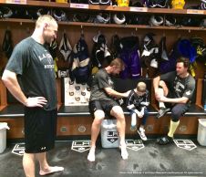 LA Kings forward Jeff Carter signs nine-year-old cancer patient Grace Bowen's jersey, while winger Marian Gaborik (left) and right wing Justin Williams (right) look on.