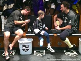 LA Kings rookie center Nick Shore (left) signs nine-year-old cancer patient Grace Bowen's jersey, while right wing Justin WIlliams (right) looks on.
